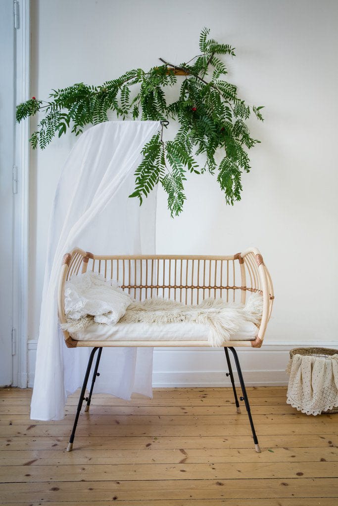 Beistellbett aus Rattan mit Schafsfell und weißem Betthimmel