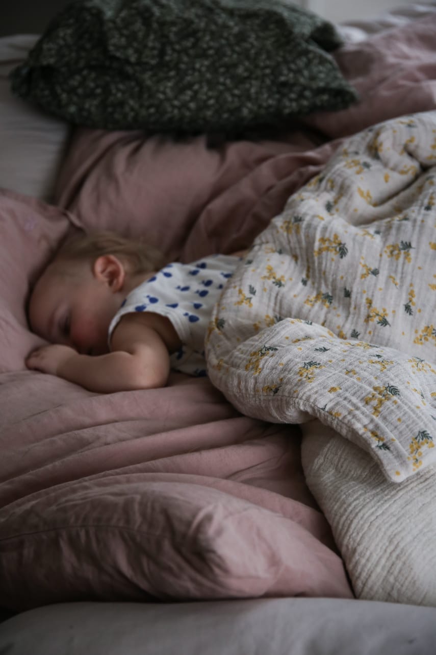 Schlafendes Baby mit floraler Bettwäsche