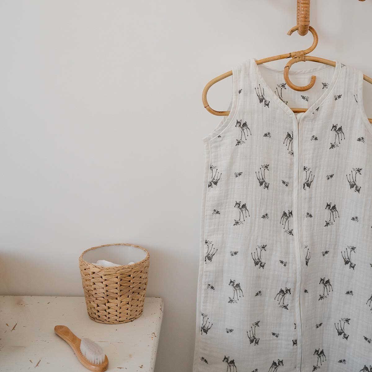 Summer sleeping bag in white with fawn print hangs on a hanger 