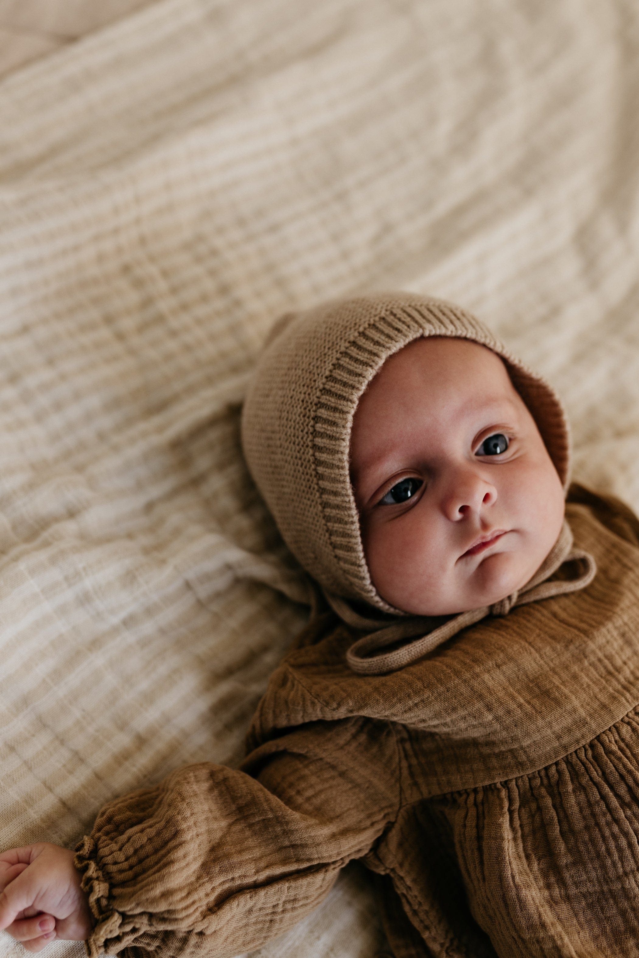 Baby in Mütze aus Merinowolle